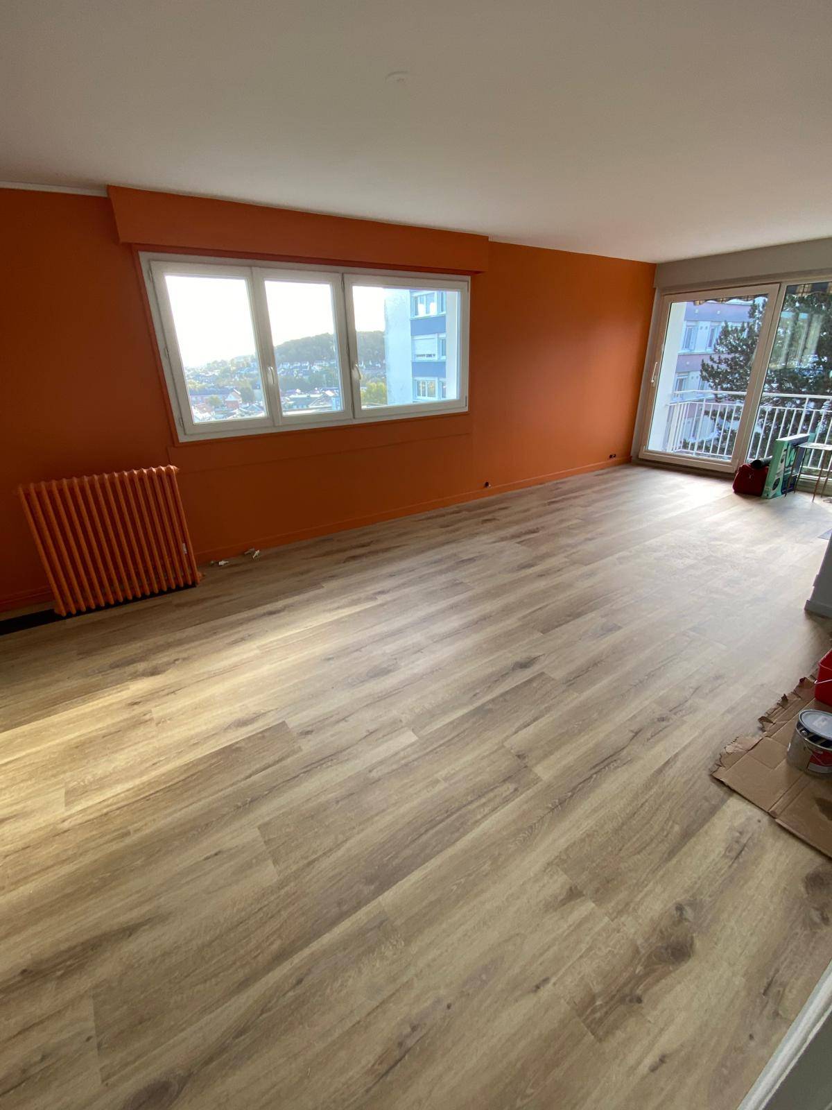Salon après rénovation avec murs orange et nouveau parquet