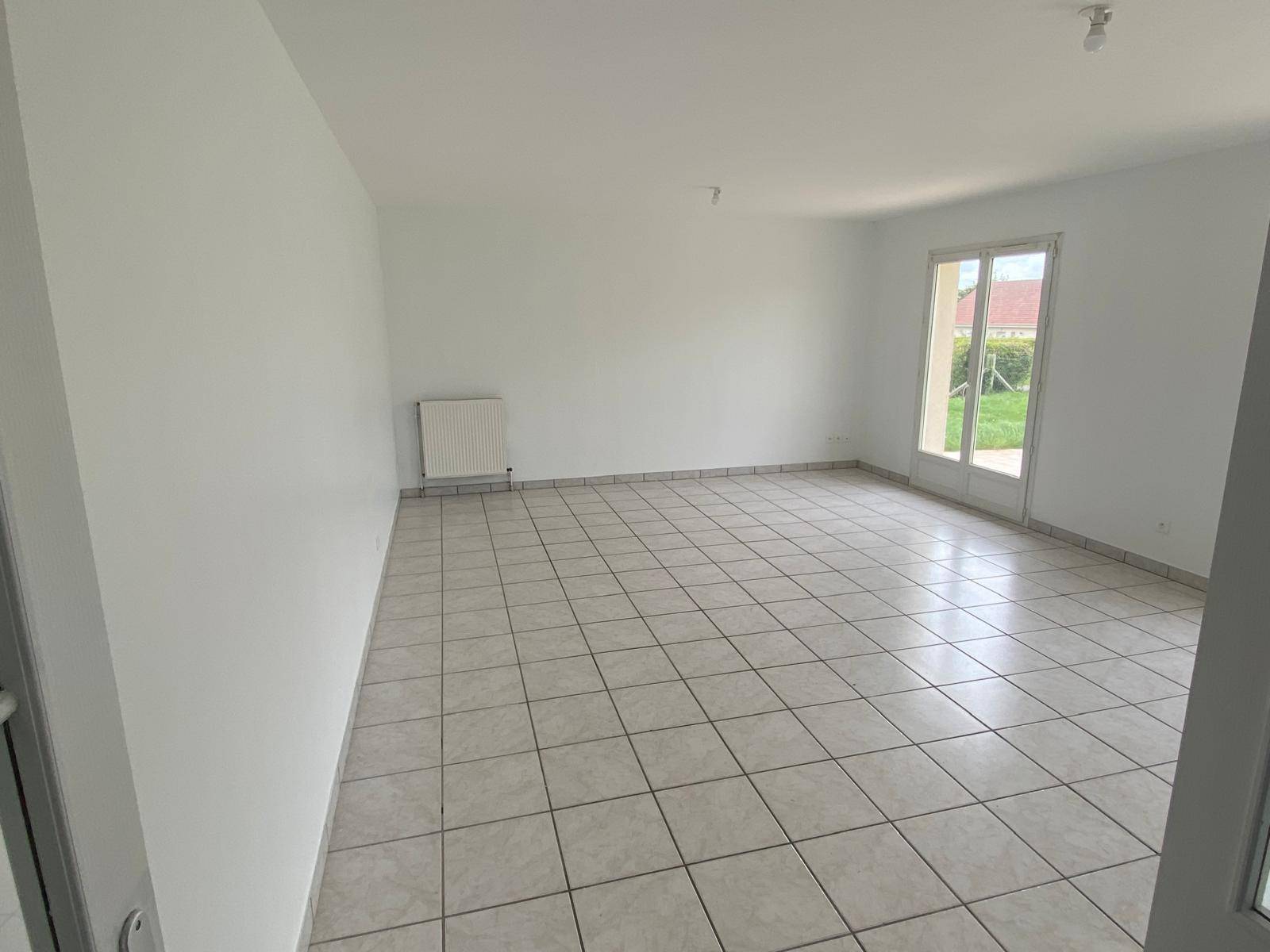 Grande pièce vide avec carrelage et murs blancs