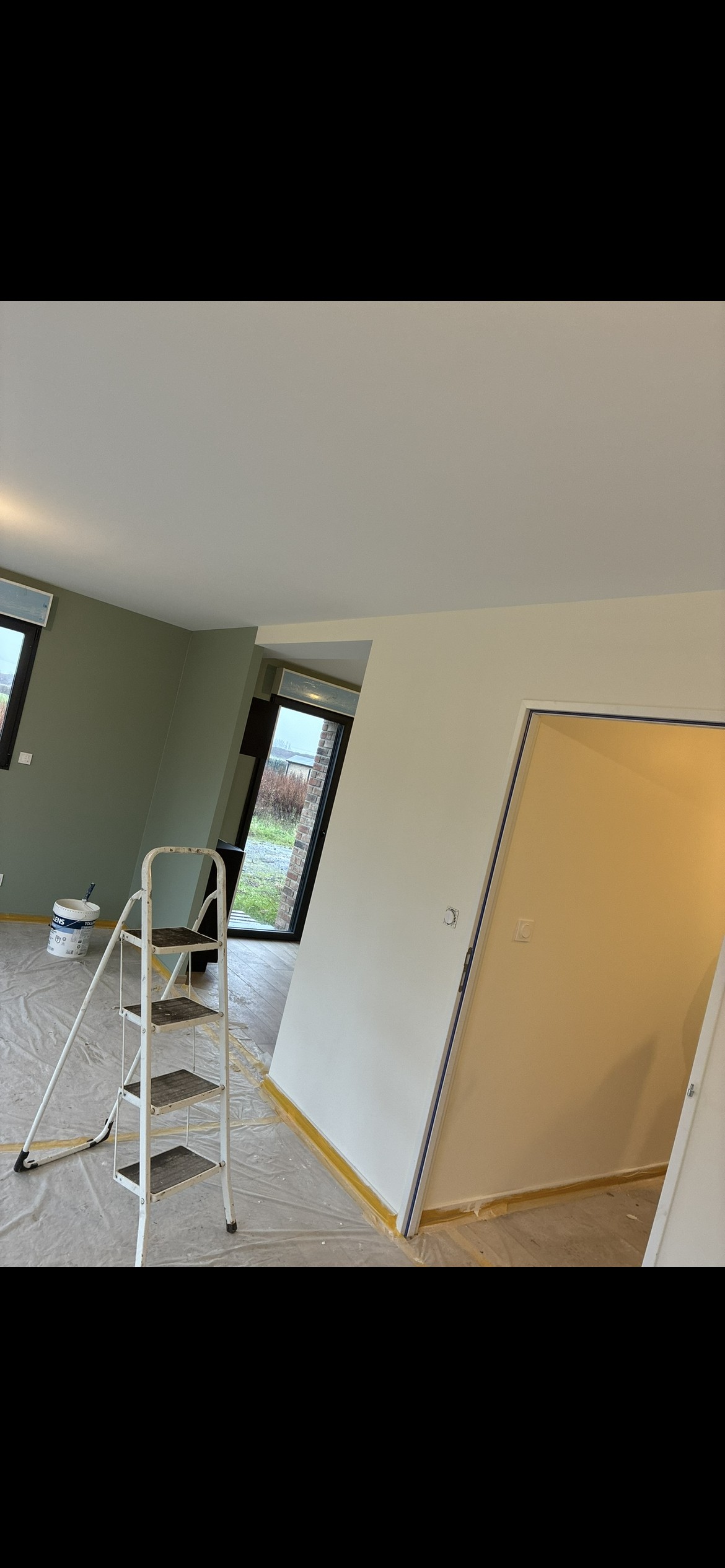 Chantier de peinture intérieure avec escabeau et bâches de protection